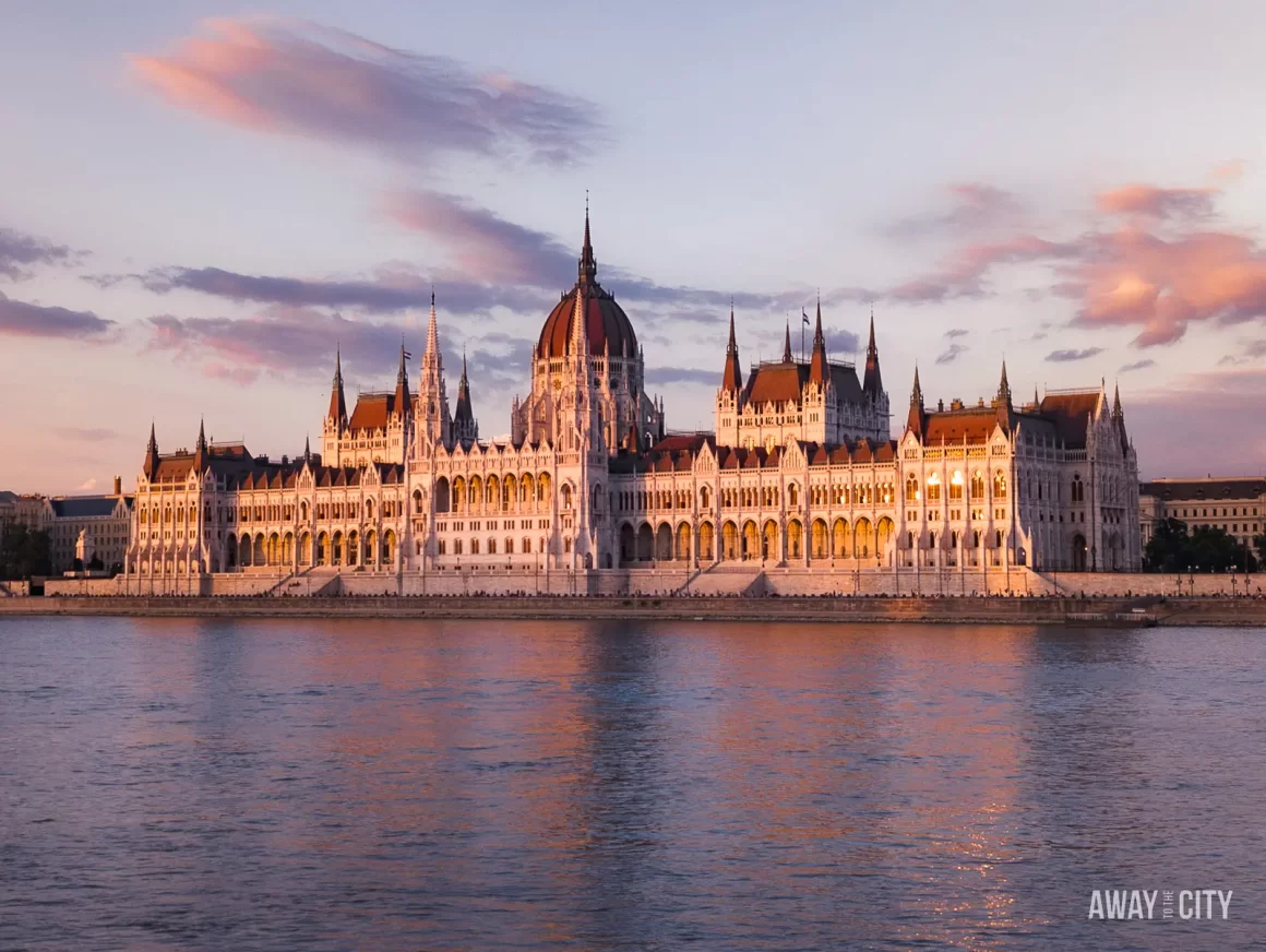 View of the Hungarian Parliament Building in Budapest, seen from the Danube River during a beautiful sunset