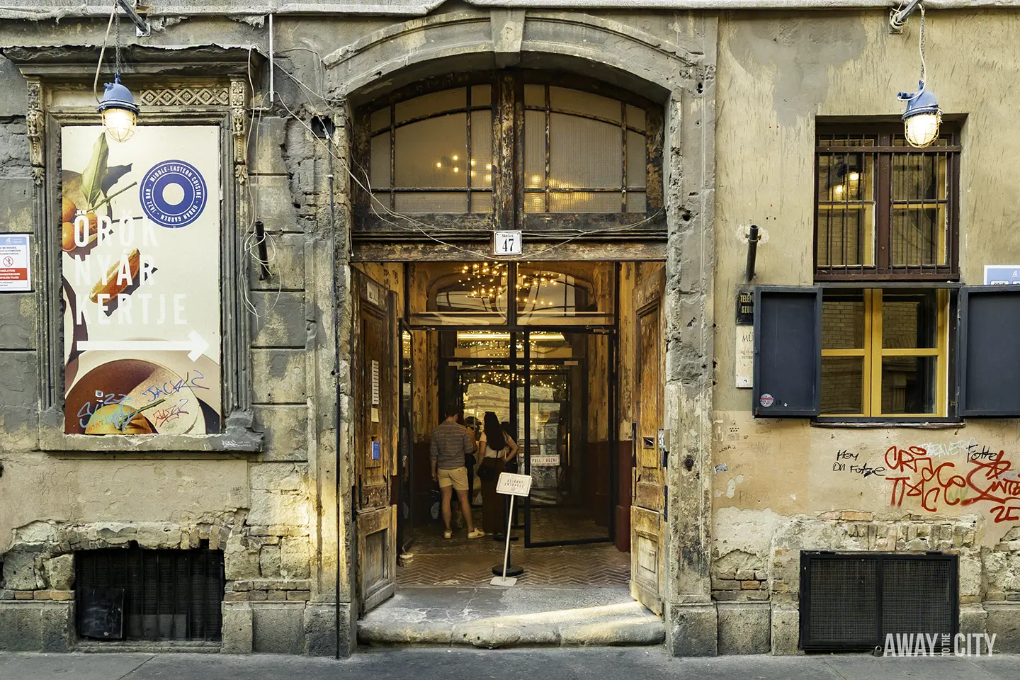 The entrance door to the Mazel Tov ruin bar in Budapest, known for its unique and artistic atmosphere.