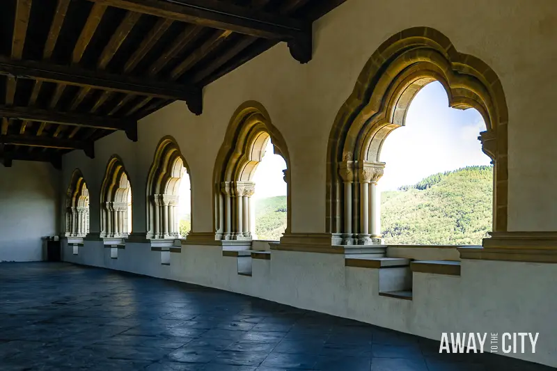 A picture of the Gallery, a spacious room within Vianden Castle in Luxembourg featuring arched windows