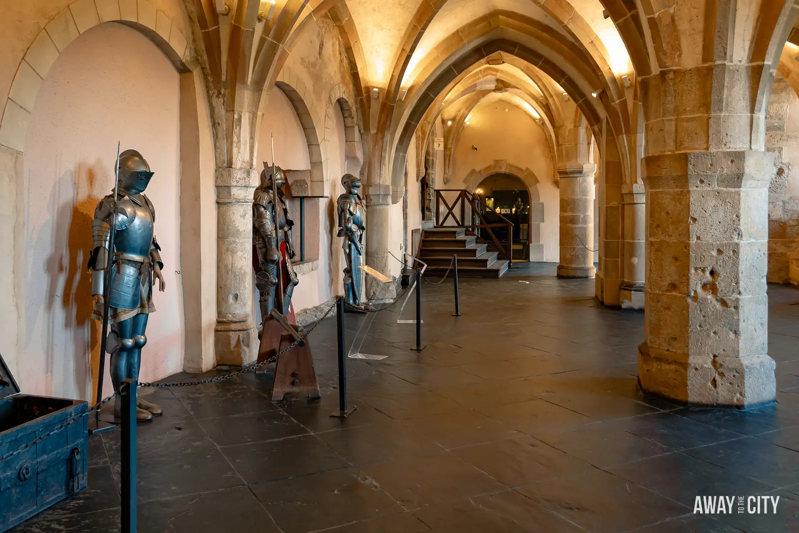 A picture of a large hall within Vianden Castle in Luxembourg displaying a collection of medieval knights' armour