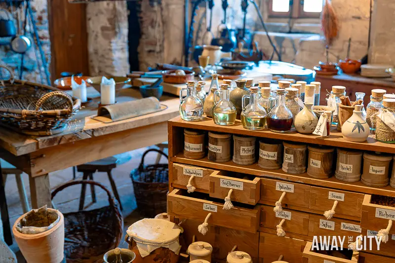 A picture of a well-stocked kitchen shelf inside Vianden Castle in Luxembourg with bottles and jars of herbs