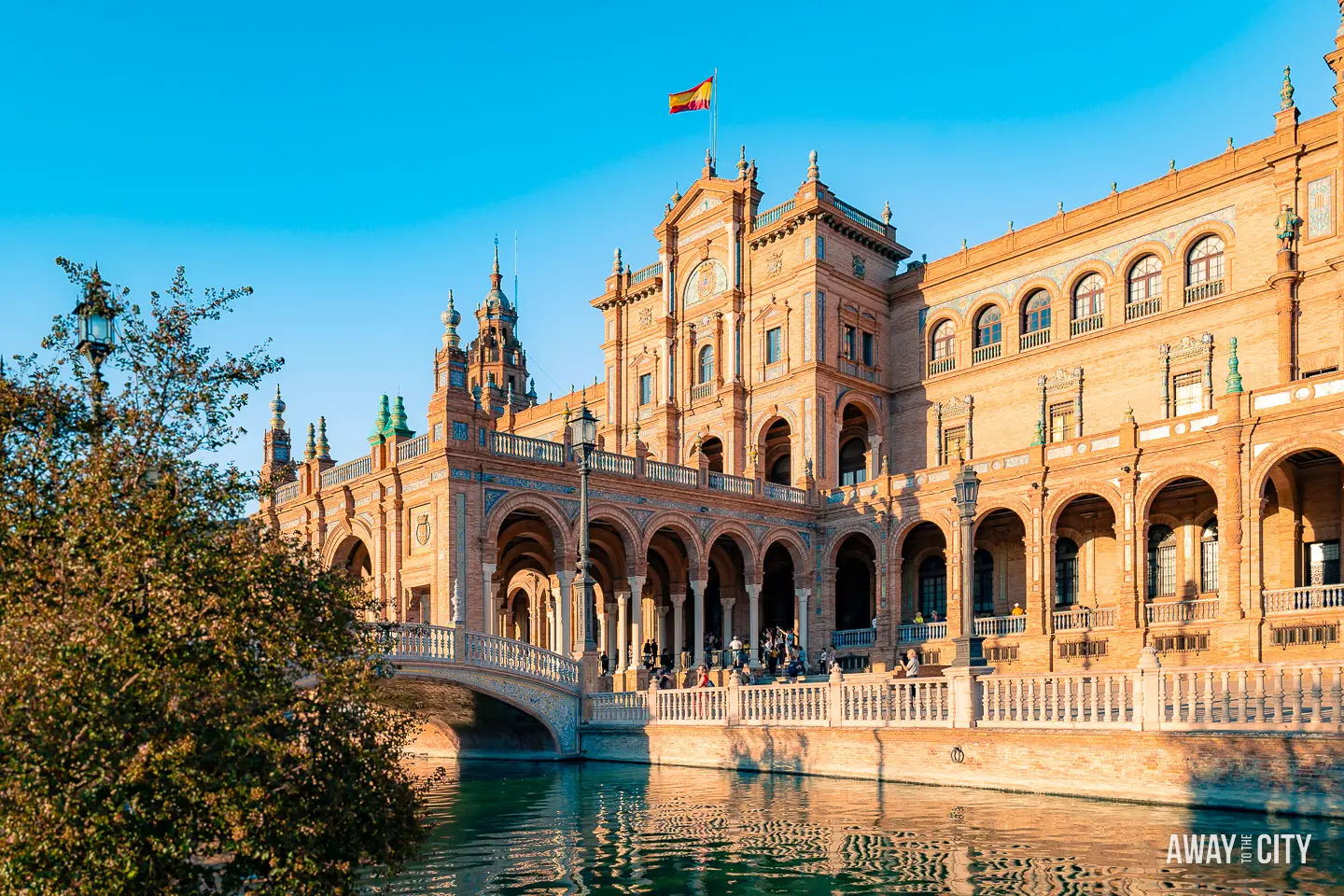 A picture of the main building of Plaza de España in Seville (Spain), with a canal and bridge adding to the scenic beauty.