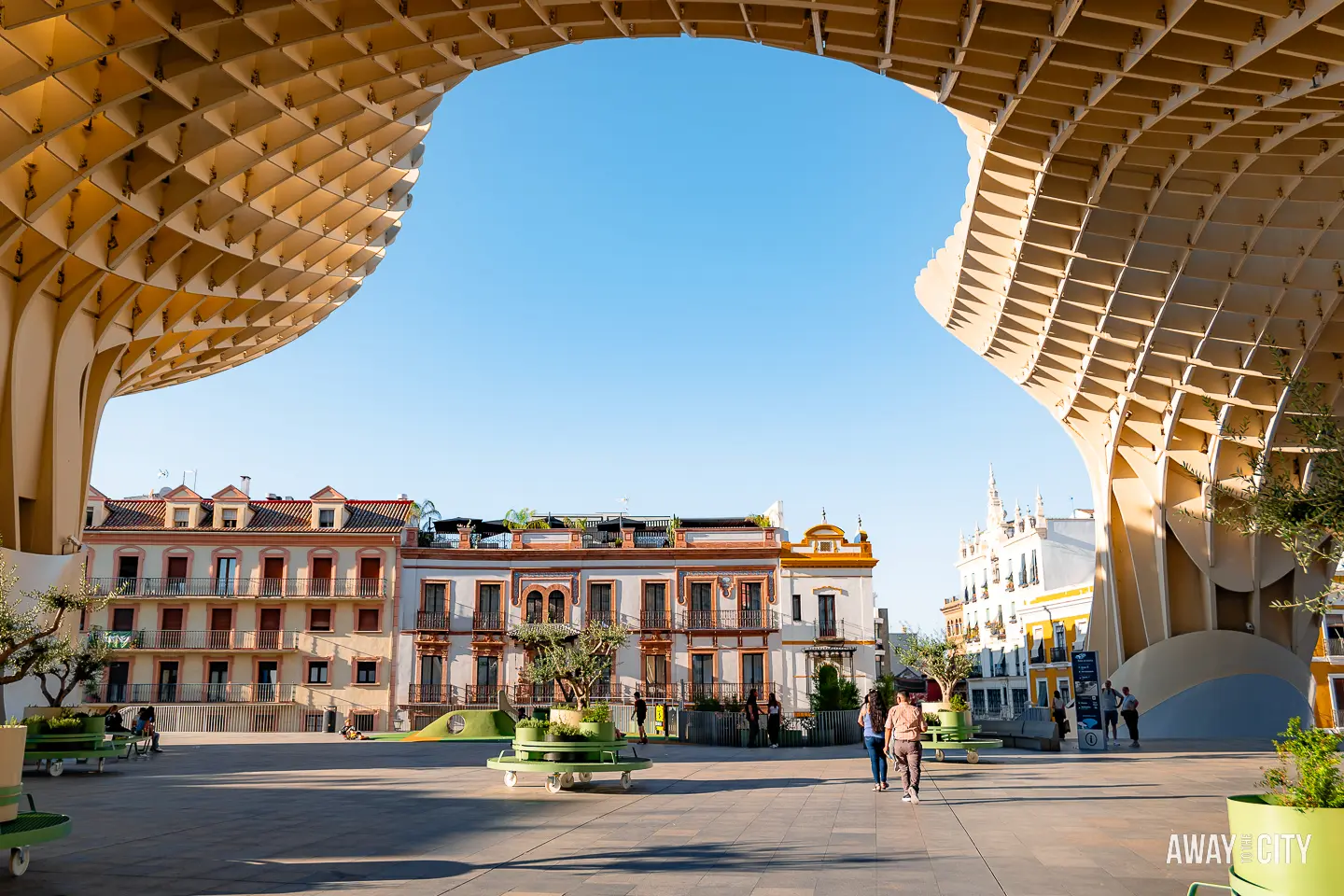 A picture of the wooden structure of Setas de Sevilla (Metropol Parasol) in Seville in the foreground and the old buildings of Seville in the background.