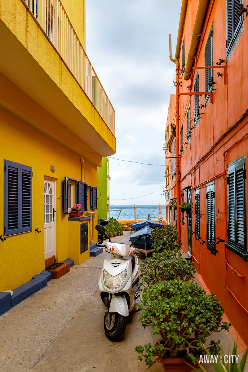 A picture of a scooter parked in a narrow alley in Catalan Bay Fishing Village.