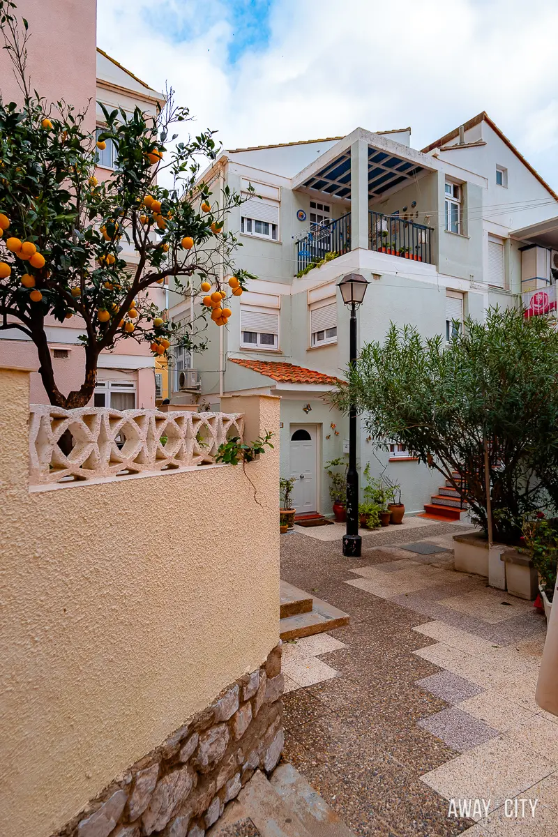A picture of buildings with an orange tree next to it in the Catalan Bay Fishing Village.
