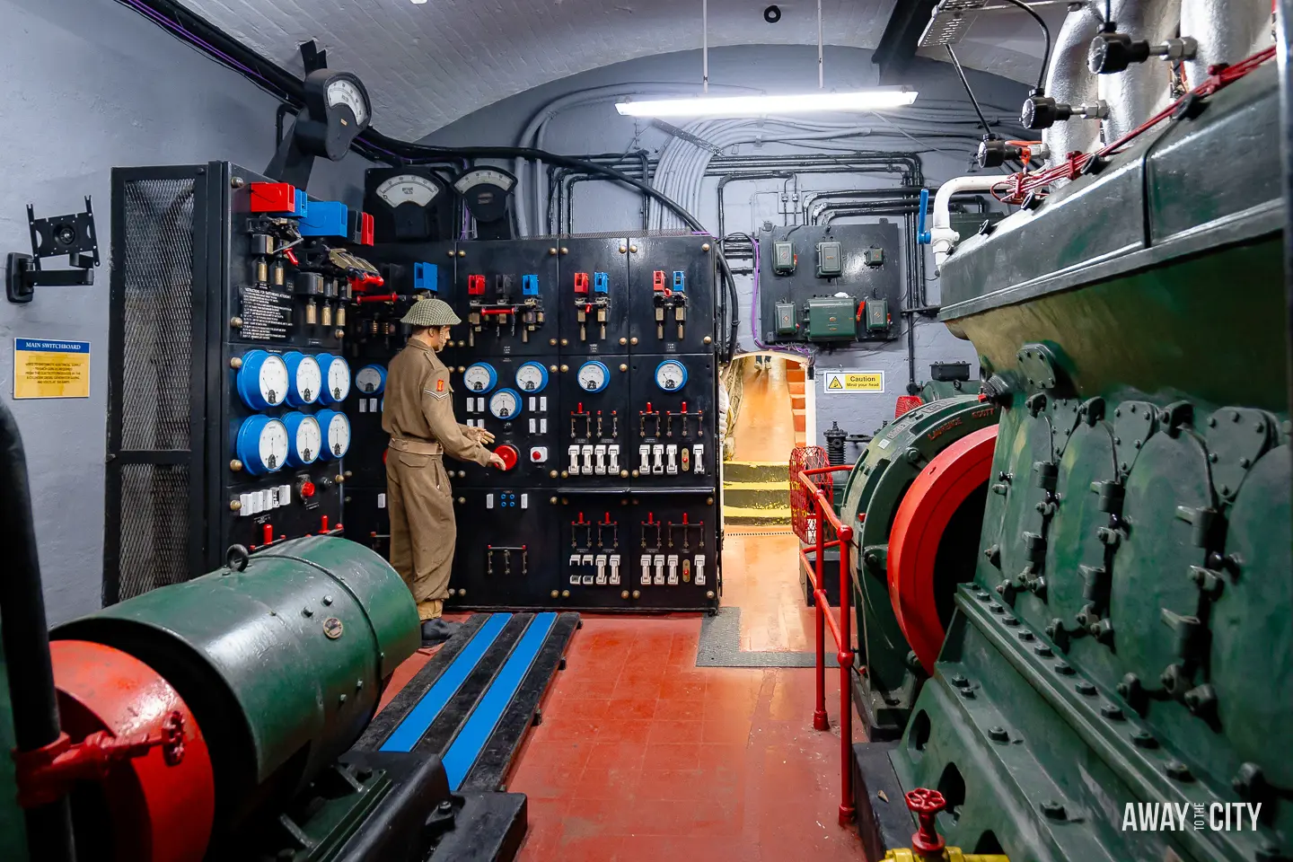 A picture of a person in a uniform standing in a room with large machines at O'Hara Battery in Gibraltar.