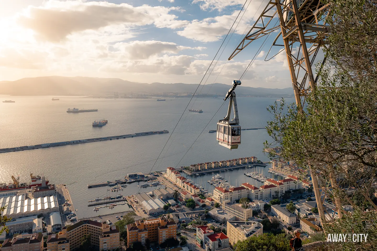 A picture of of Gibraltar's Cable Car in the foreground and the city underneath in the background, taken during sunset.