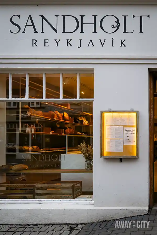 The façade of Sandholt Bakery, a family-run bakery serving fresh bread, pastries, and sandwiches in Reykjavik, making it a perfect place to warm up during the cold winter in Iceland.