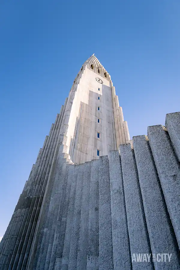 A close up of the Hallgrímskirkja church in Reykjavik is captured against a clear sky, showcasing its unique and towering architecture.