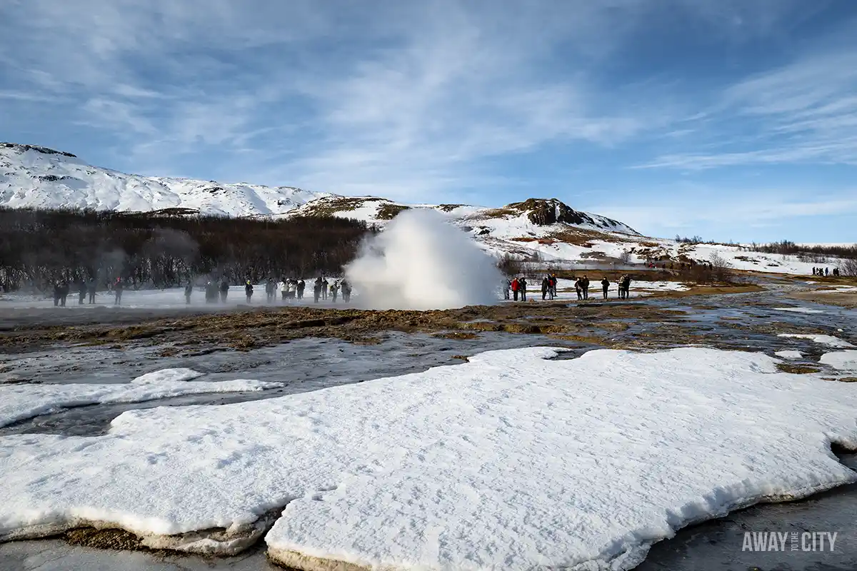A group of people at the Geysir Geothermal Area in Iceland where the biggest geyser there, Strokkur, erupts every five minutes.
