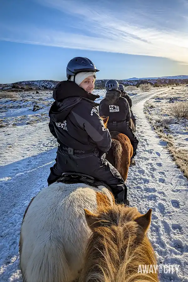 A person on an Icelandic Horse during a riding tour through Iceland’s volcanic fields, forests, and plains covered in snow in Reykjavik in winter.