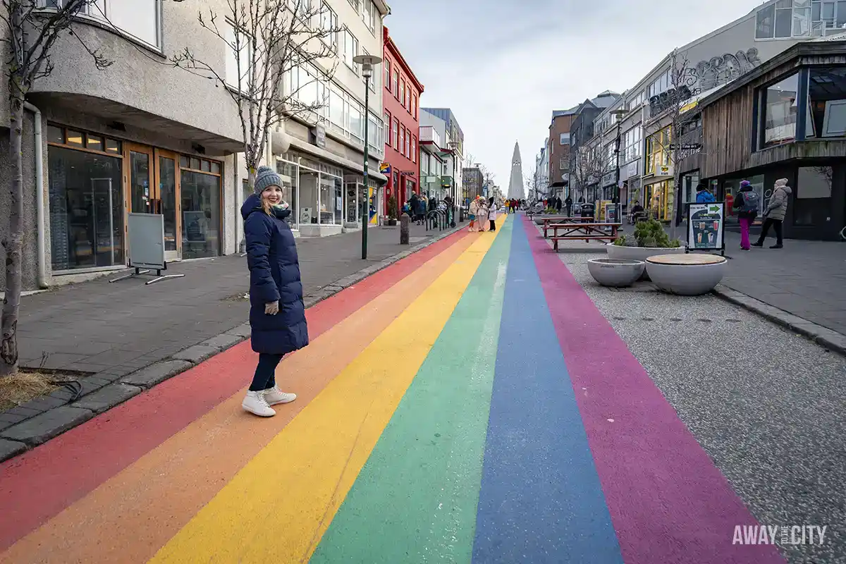 A person standing on Rainbow Street, one of the best things to see in Reykjavik in Iceland in winter.