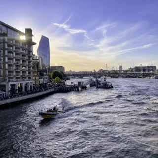 A boat on the water, with the Southwark district in the background.