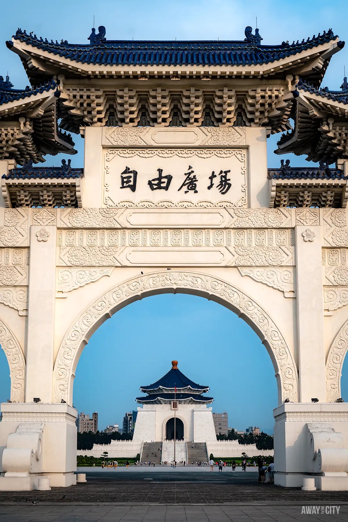 An ornate gate with traditional Chinese architectural elements, leading to a prominent memorial hall, with the text "Away To The City" in the bottom right corner.