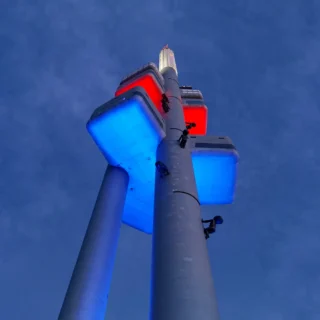 The Žižkov Television Tower in Prague, Czech Republic, illuminated against the twilight sky.