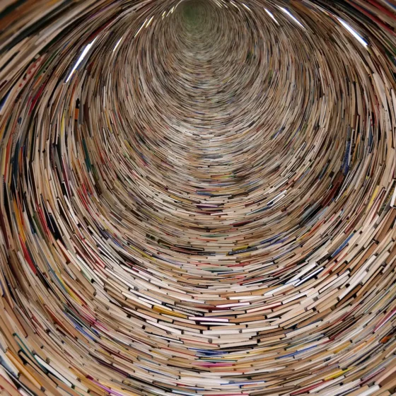 A mesmerising view looking down the length of a tunnel constructed entirely from stacked books, showing Prague's Infinity Book Tower.