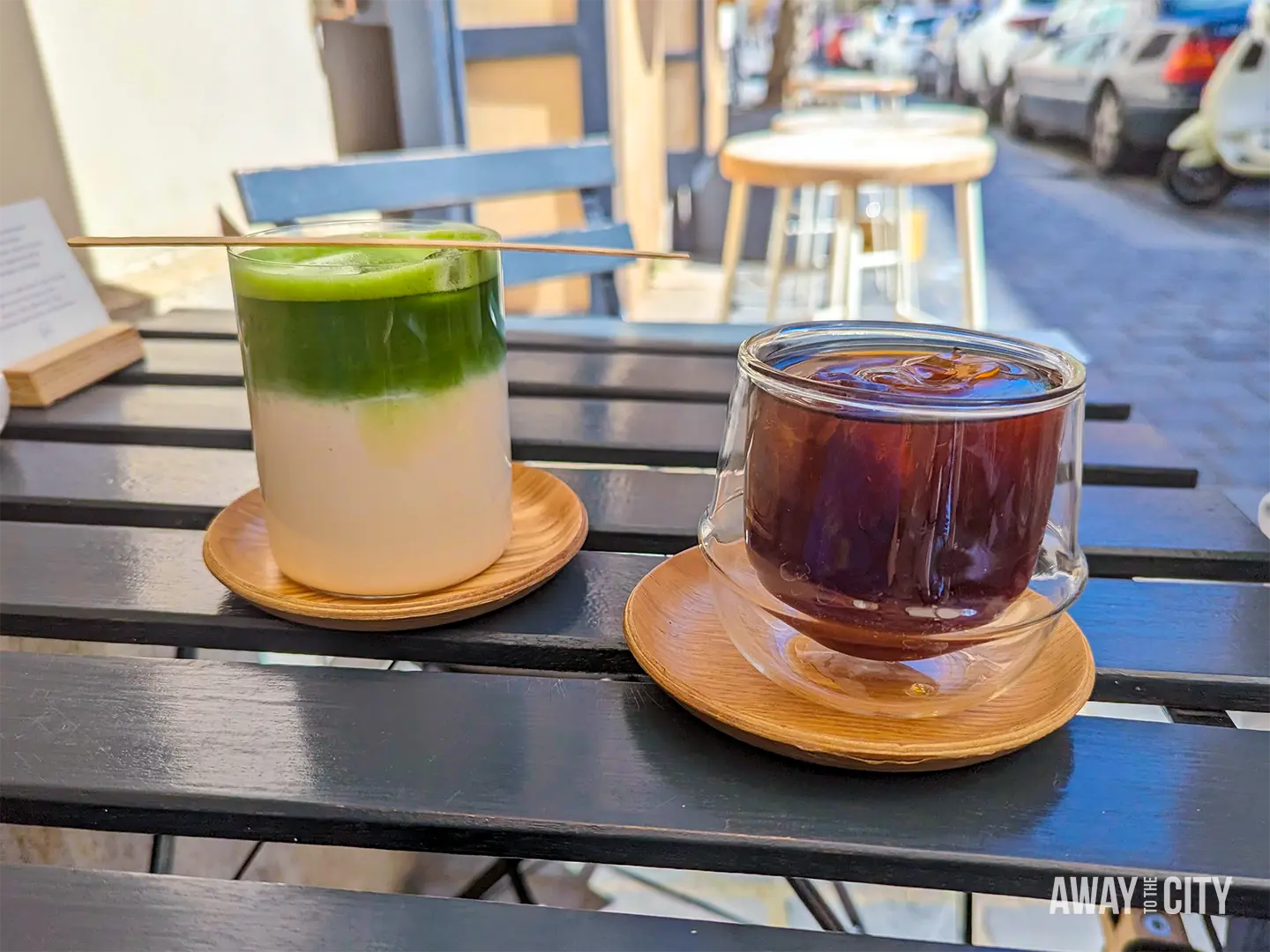 Coffee and green tea on an outdoor café table, illustrating staying in daylight and drinking caffeine to help manage jet lag.