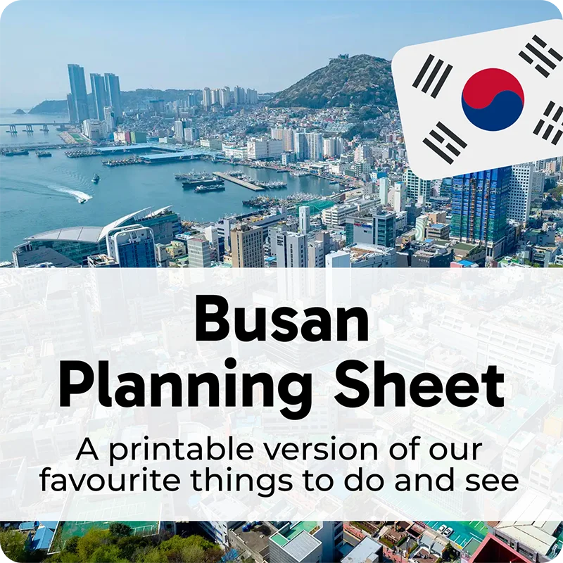 Aerial view of Busan coastline and skyline with South Korean flag icon and overlay text 'Busan Planning Sheet' and 'A printable version of our favourite things to do and see'.