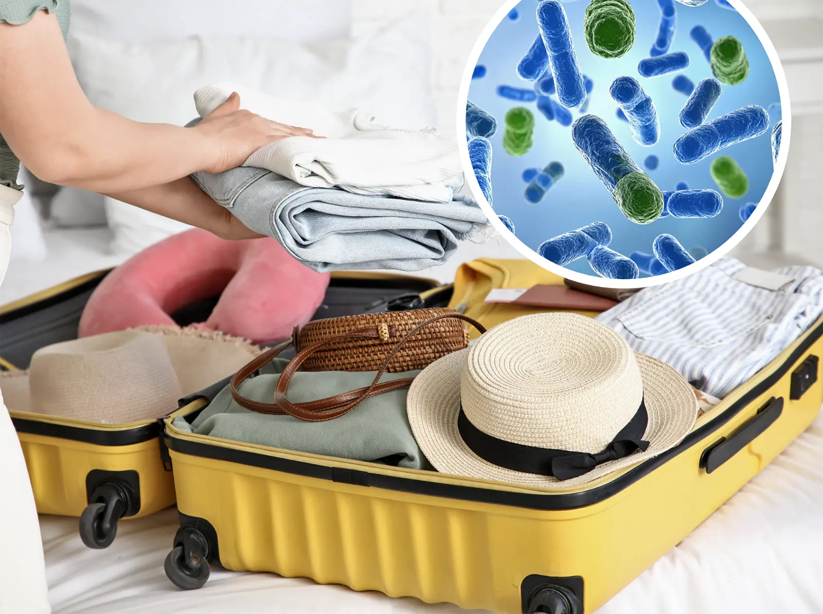 A yellow open suitcase full of clothes and a sun hat, with an inset circle showing a magnified illustration of bacteria.