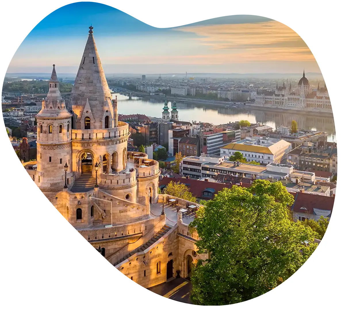 A stunning sunrise view of Fisherman's Bastion in Budapest, overlooking the Danube River and the Hungarian Parliament Building.