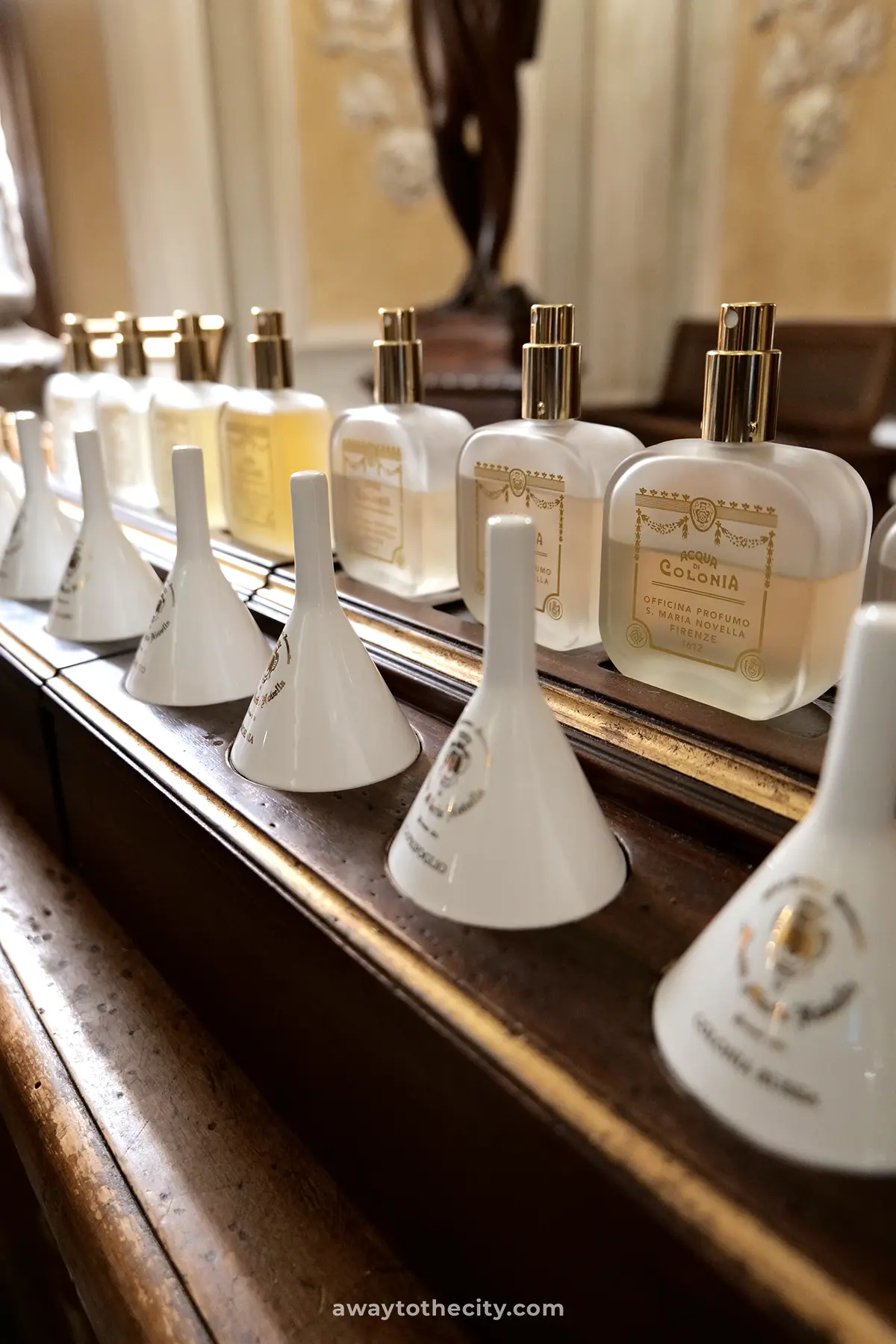 Elegant perfume bottles and delicate white funnels are meticulously displayed at the historic Officina Profumo-Farmaceutica di Santa Maria Novella.
