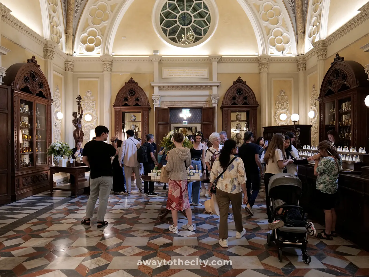 Visitors explore the ornate main hall of the Officina Profumo-Farmaceutica di Santa Maria Novella, a highlight on a 2-day Florence itinerary.