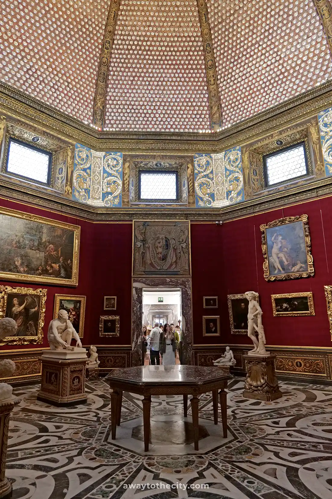 Visitors admire the art and architecture within the octagonal Tribuna of the Uffizi Gallery.
