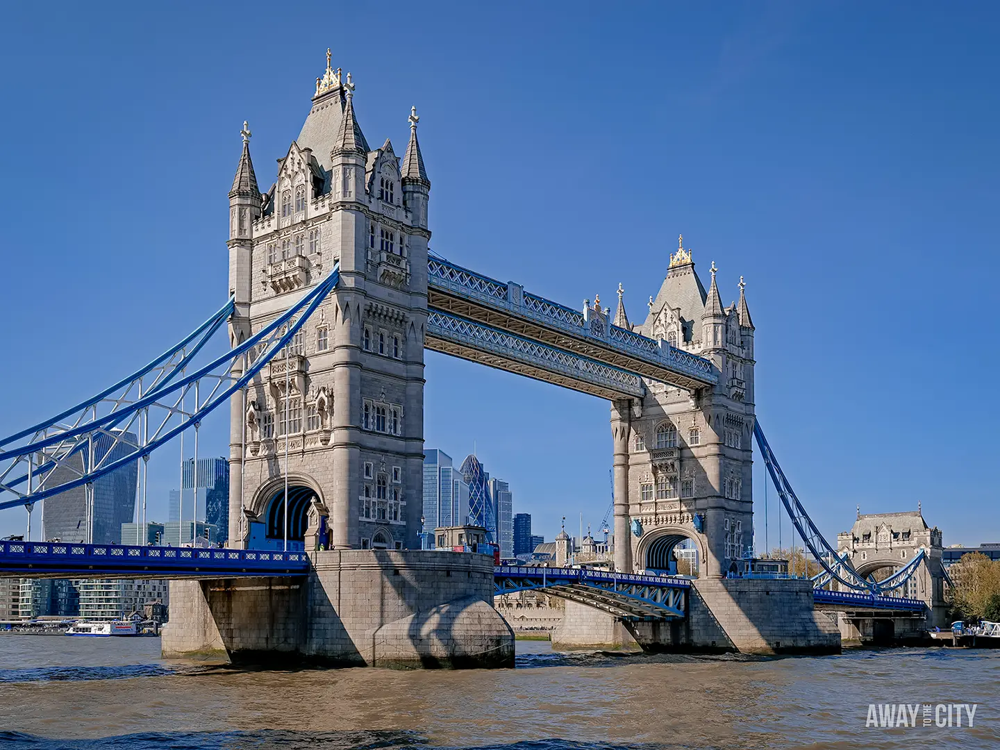 A classic side-on view of London's Tower Bridge against a bright blue sky.