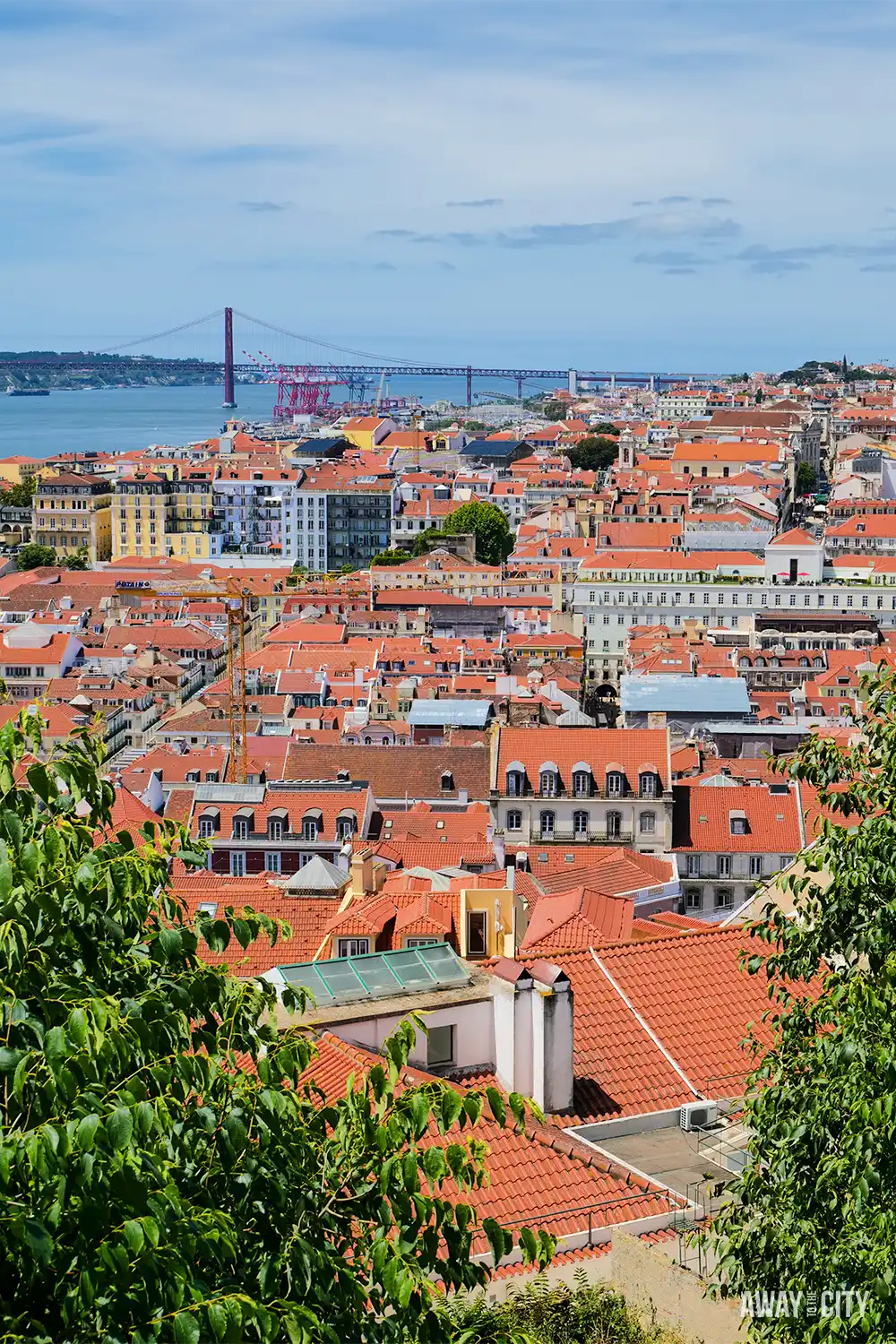 Panoramic view over Lisbon’s terracotta rooftops from Castelo de São Jorge (Saint George's Castle), with the Tagus River and bridge beyond.