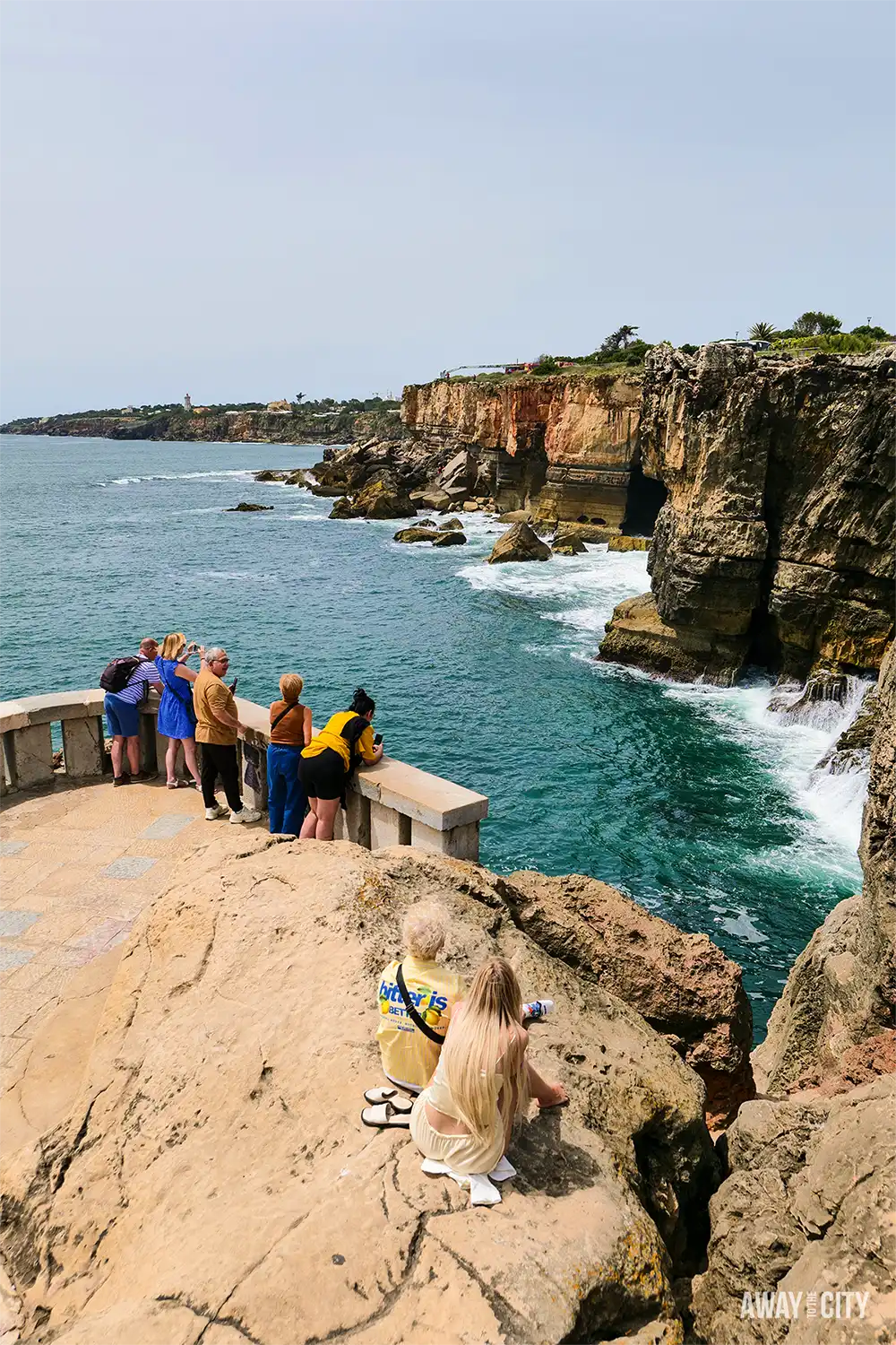 View from the Boca do Inferno cliffs in Cascais, with visitors overlooking dramatic rock formations and the Atlantic Ocean.