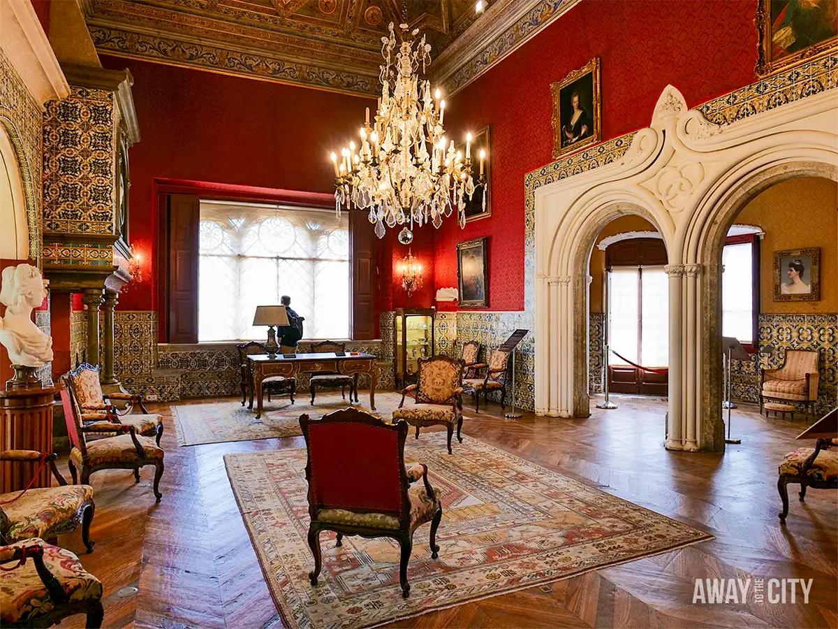 Elegant room inside the Museu Condes de Castro Guimarães Palace in Cascais, featuring chandeliers, period furniture and ornate décor.