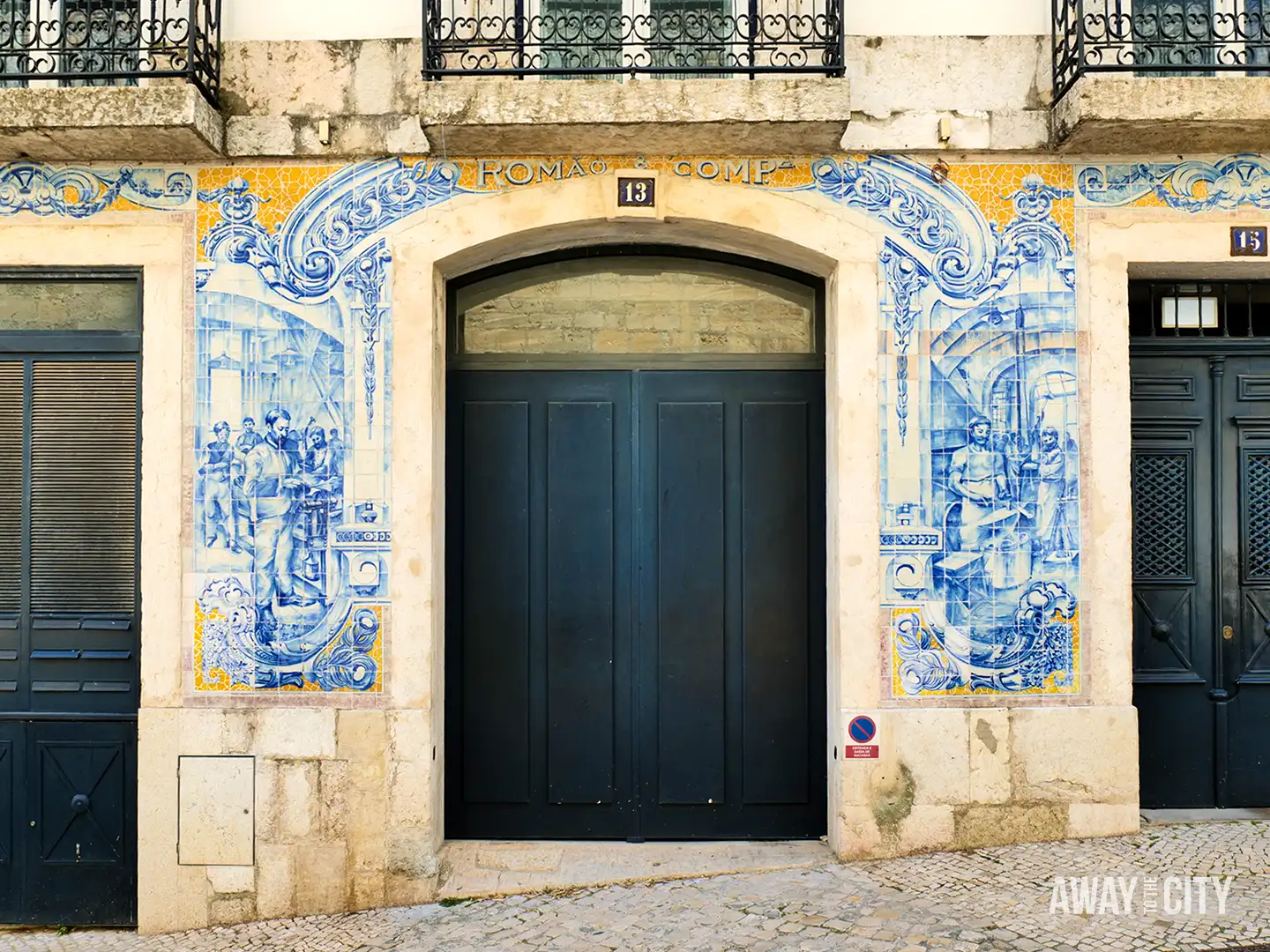 Blue-and-white azulejo tiles frame a doorway on a traditional building façade in Lisbon.