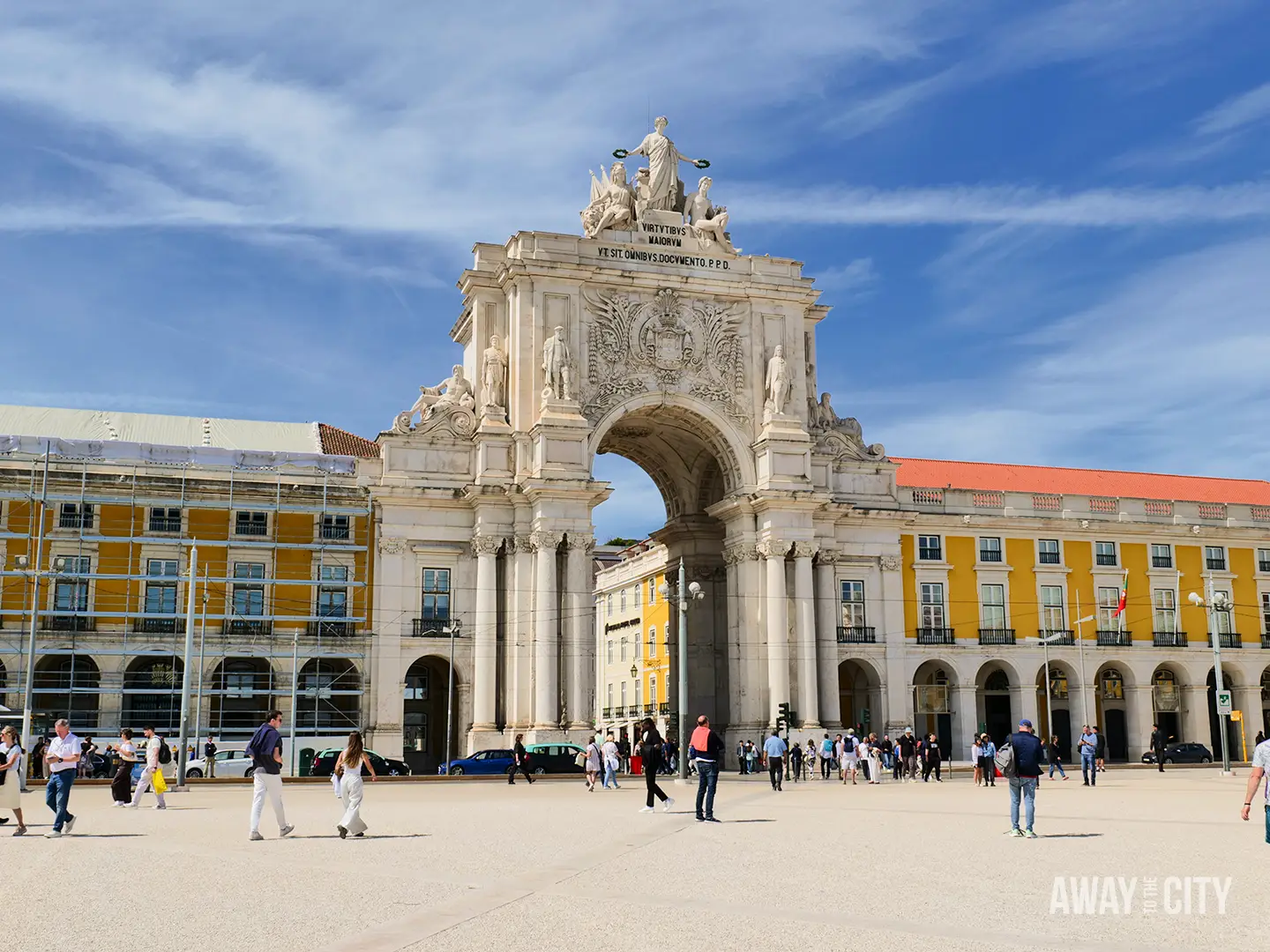 Rua Augusta Arch rises above Praça do Comércio in Lisbon, with visitors crossing the expansive riverside square.
