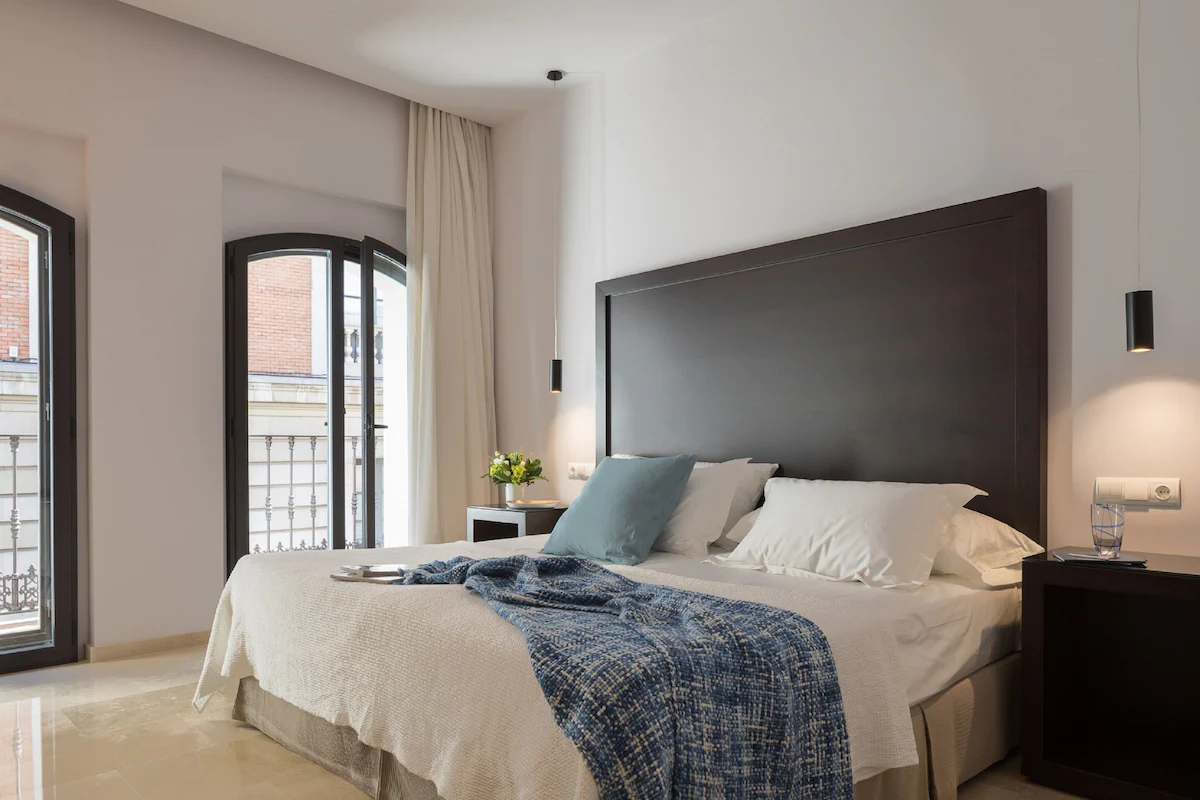 A clean and modern hotel room with a large bed and a balcony door.