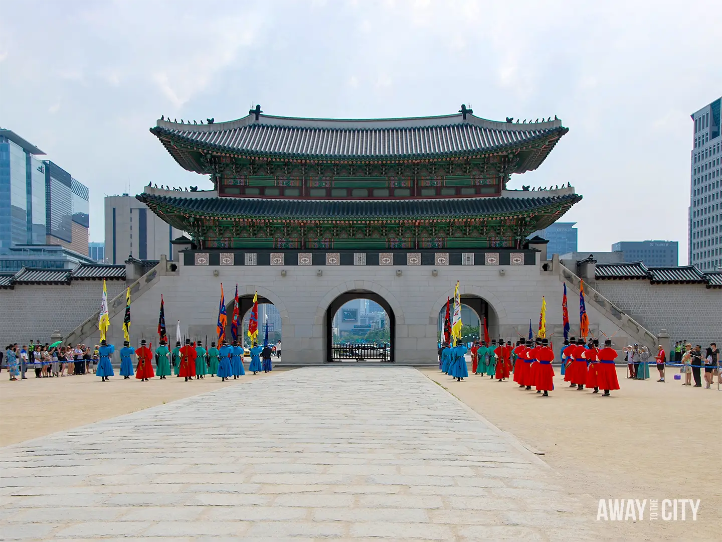 Changing of the Guard ceremony at Gyeongbokgung Palace, with colourful guards lined across the courtyard before the main palace gate.