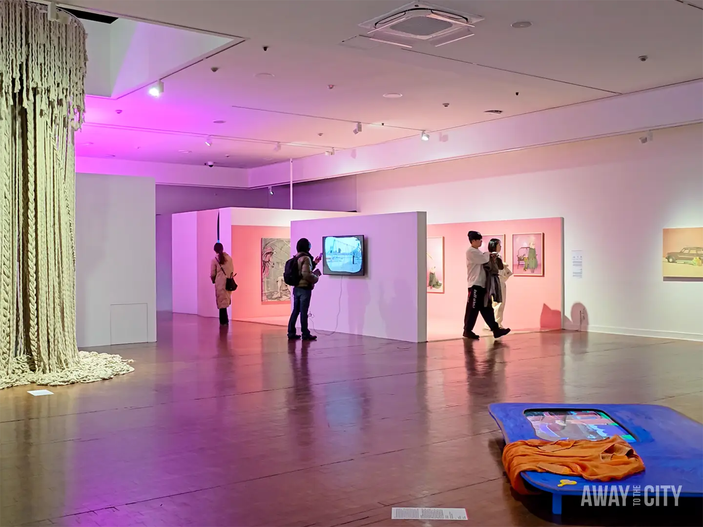 Visitors explore contemporary exhibitions at Seoul Museum of Art, featuring large textile installation, digital artworks and softly coloured gallery lighting.