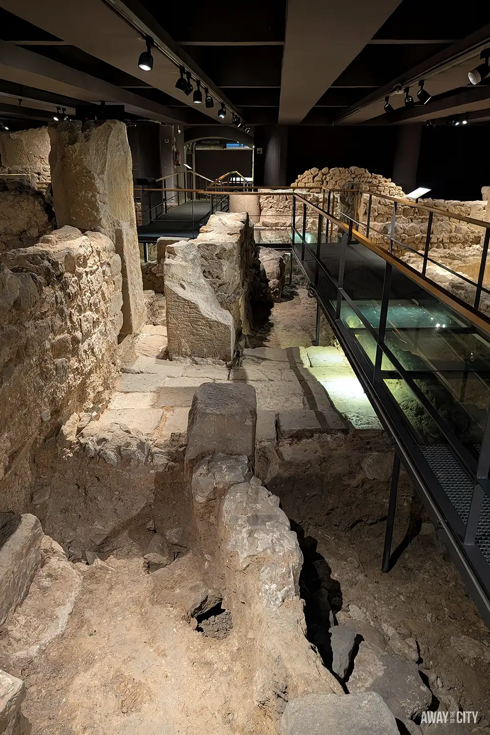 The archaeological remains of Roman Barcino underground at the MUHBA museum, with a modern walkway for viewing.