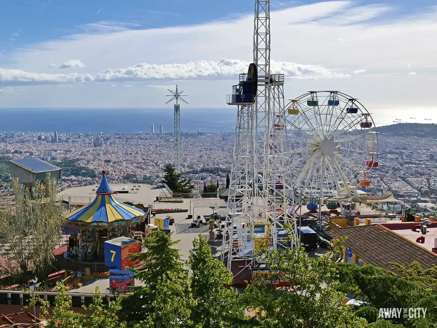 An expansive view from Mount Tibidabo showing the Tibidabo Amusement Park rides against the Barcelona cityscape and the sea.