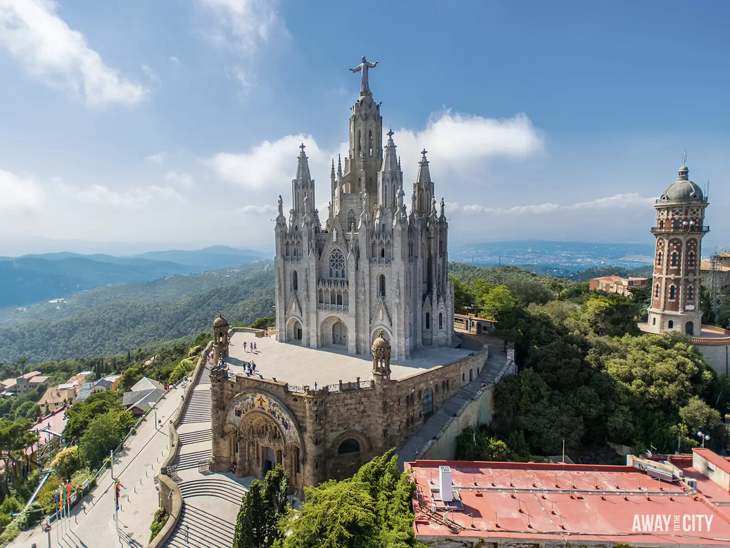 The grand Temple Expiatori del Sagrat Cor on Mount Tibidabo, featuring a statue of Jesus atop the church, overlooks Barcelona.