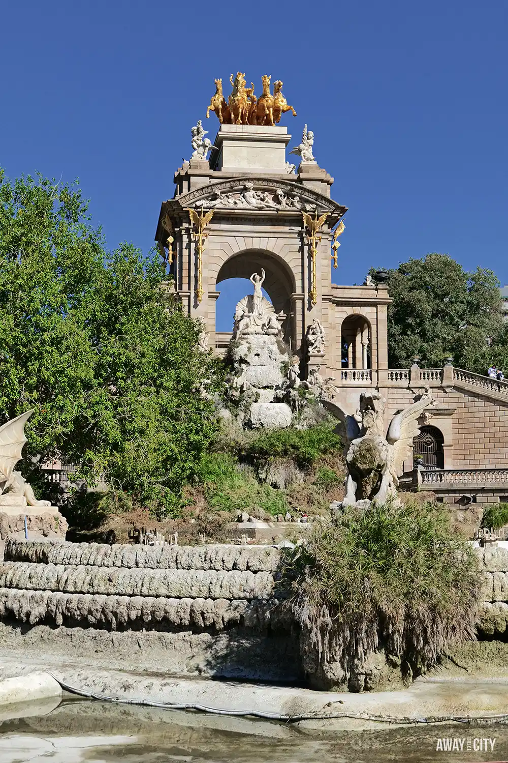 The Cascada Monumental fountain in Parc de la Ciutadella, featuring a golden chariot on top and surrounding stonework and greenery.