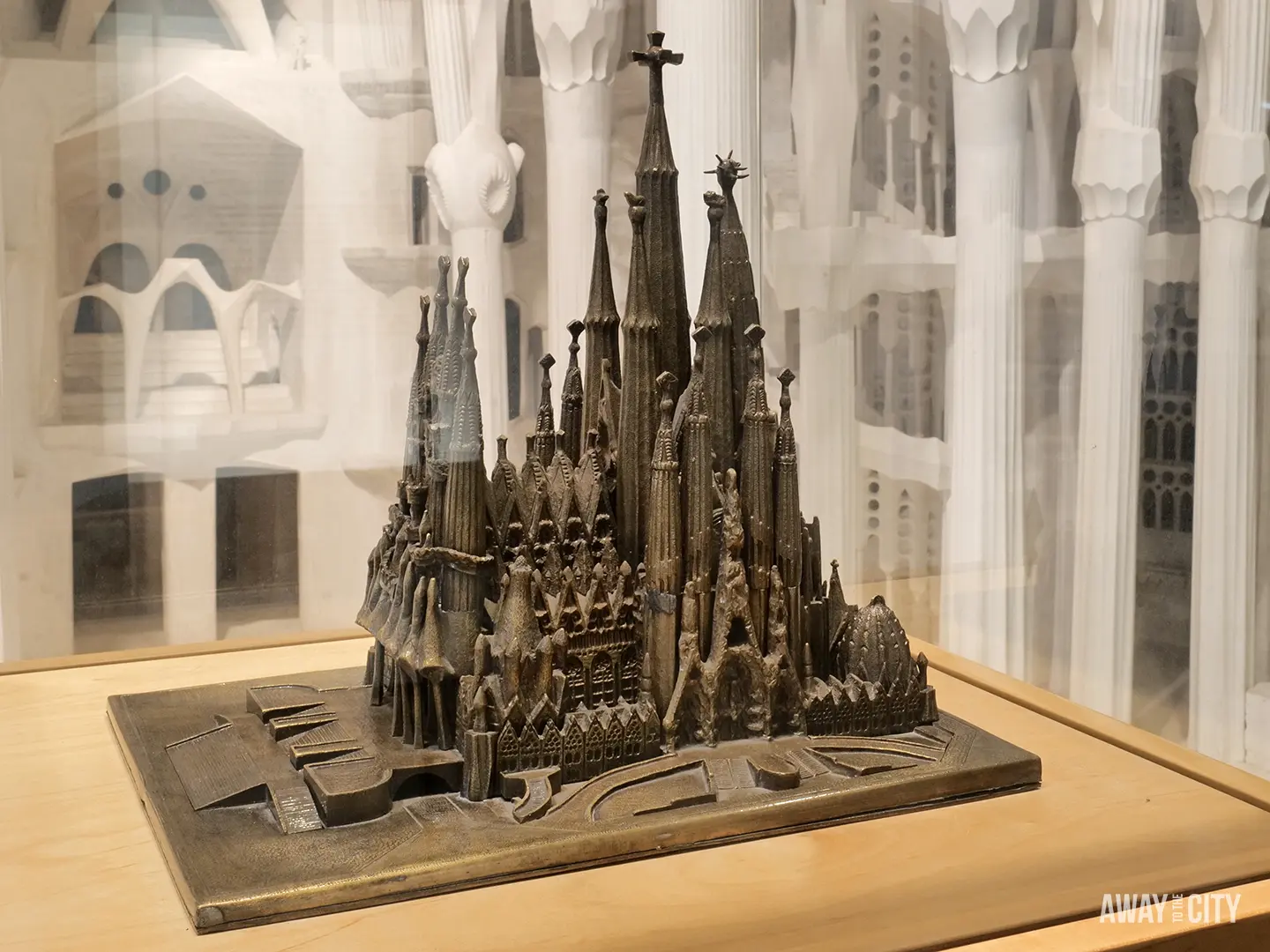 A bronze architectural model of the Sagrada Família's famous spires sits on a wooden plinth in the museum.