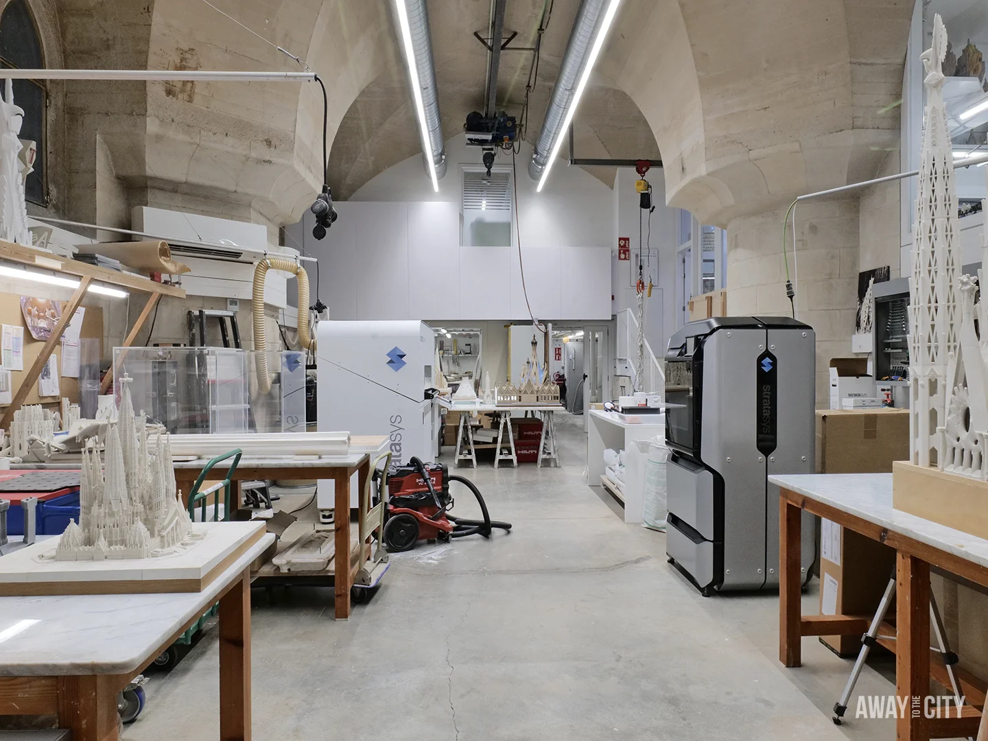 The Sagrada Família's workshop is visible, showing 3D printers, tools, and detailed architectural models.