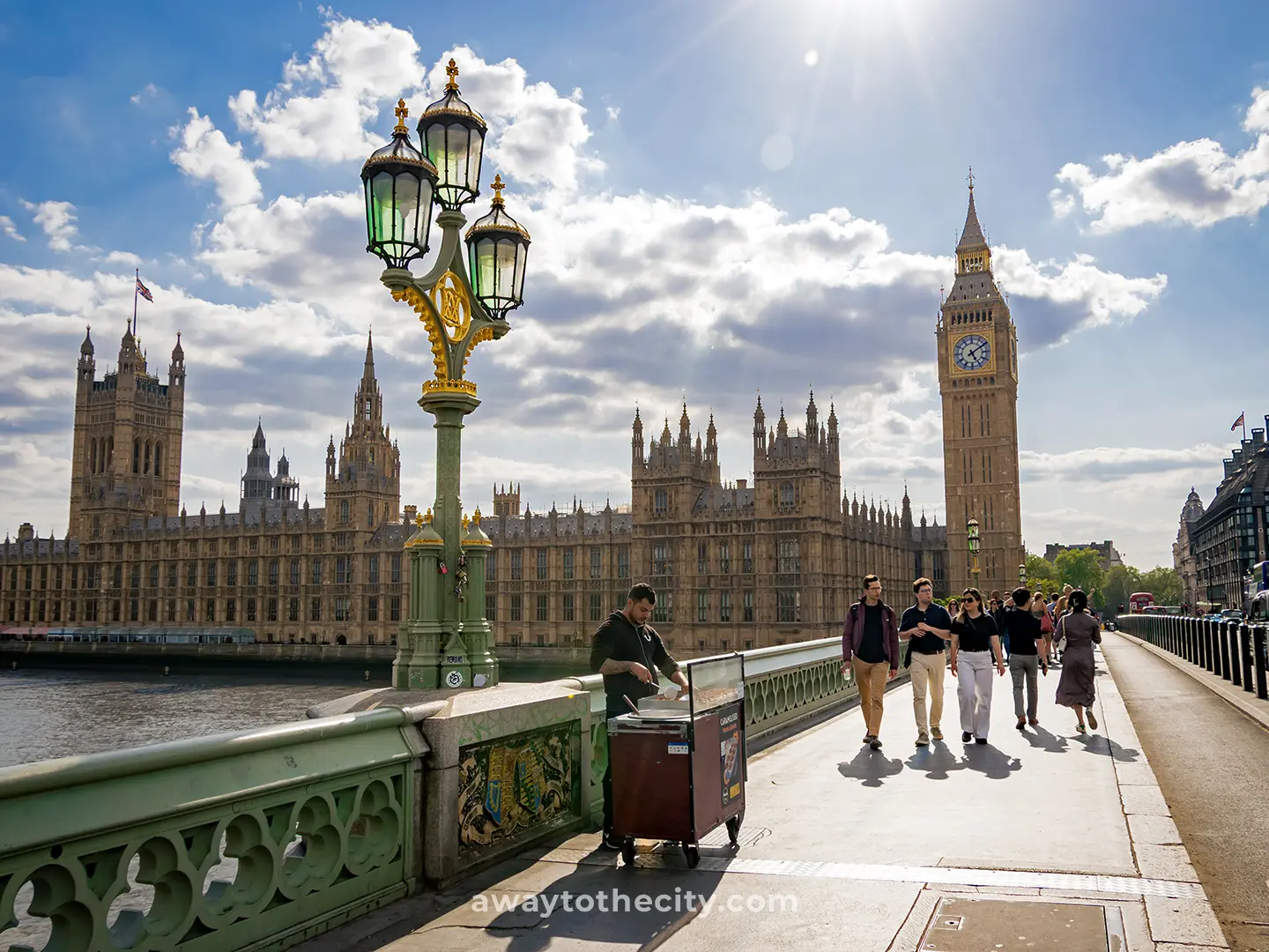 A group of people walking on Westminster Bridge in London with Big Ben and the Palace of Westminster (Houses of Parliament) in the background.