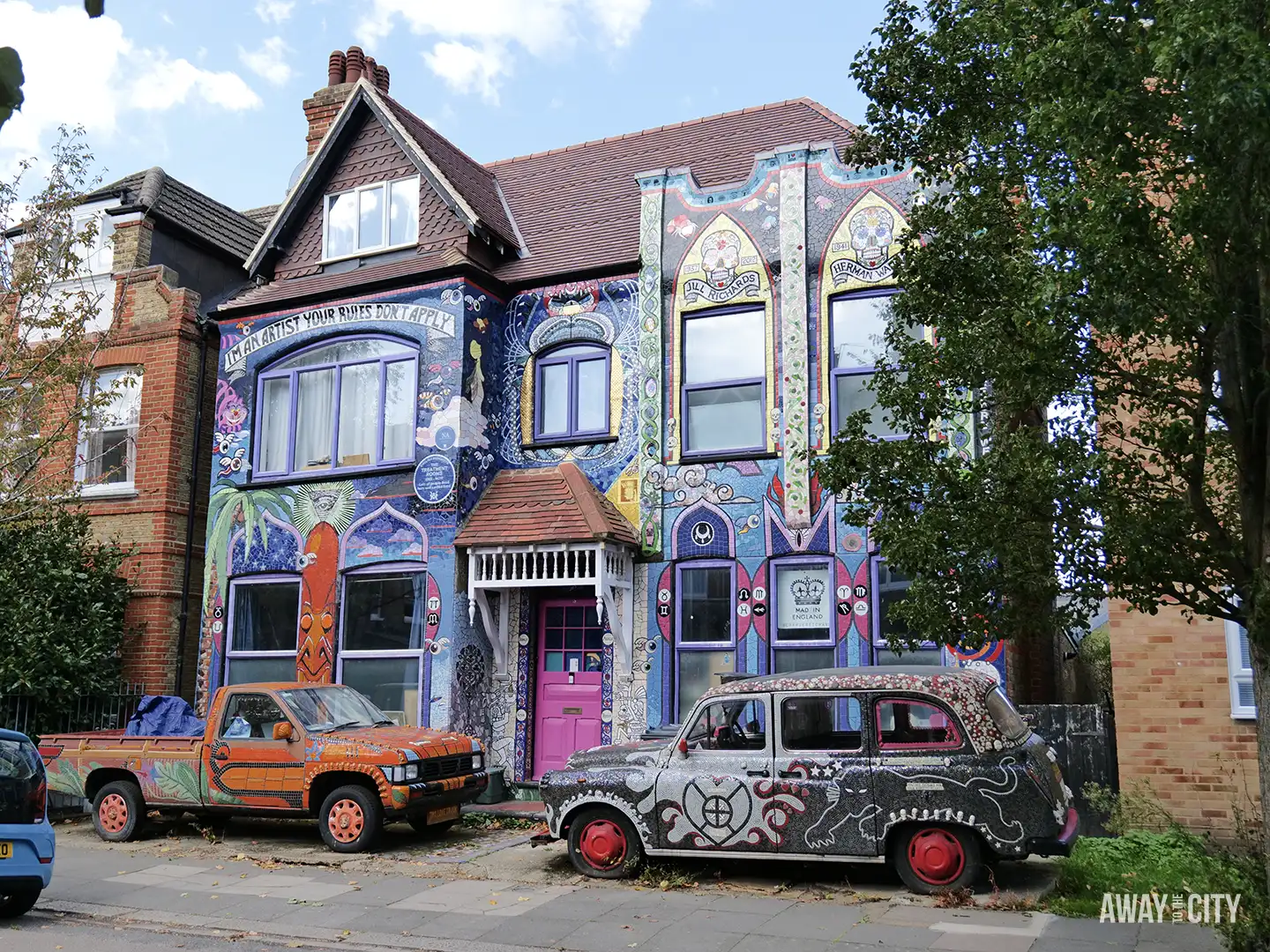 A quirky house in Chiswick, London, covered completely in a colourful, intricate mosaic with two painted cars parked outside.