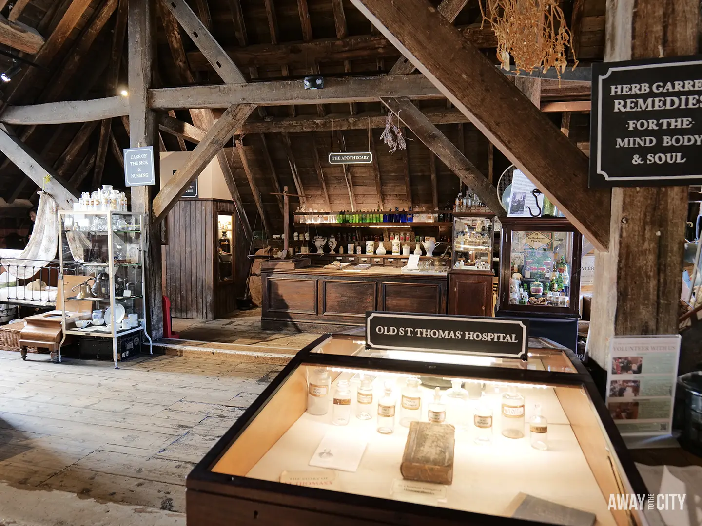 The old apothecary display featuring wooden beams, historical bottles, and a glass case with ancient remedies.