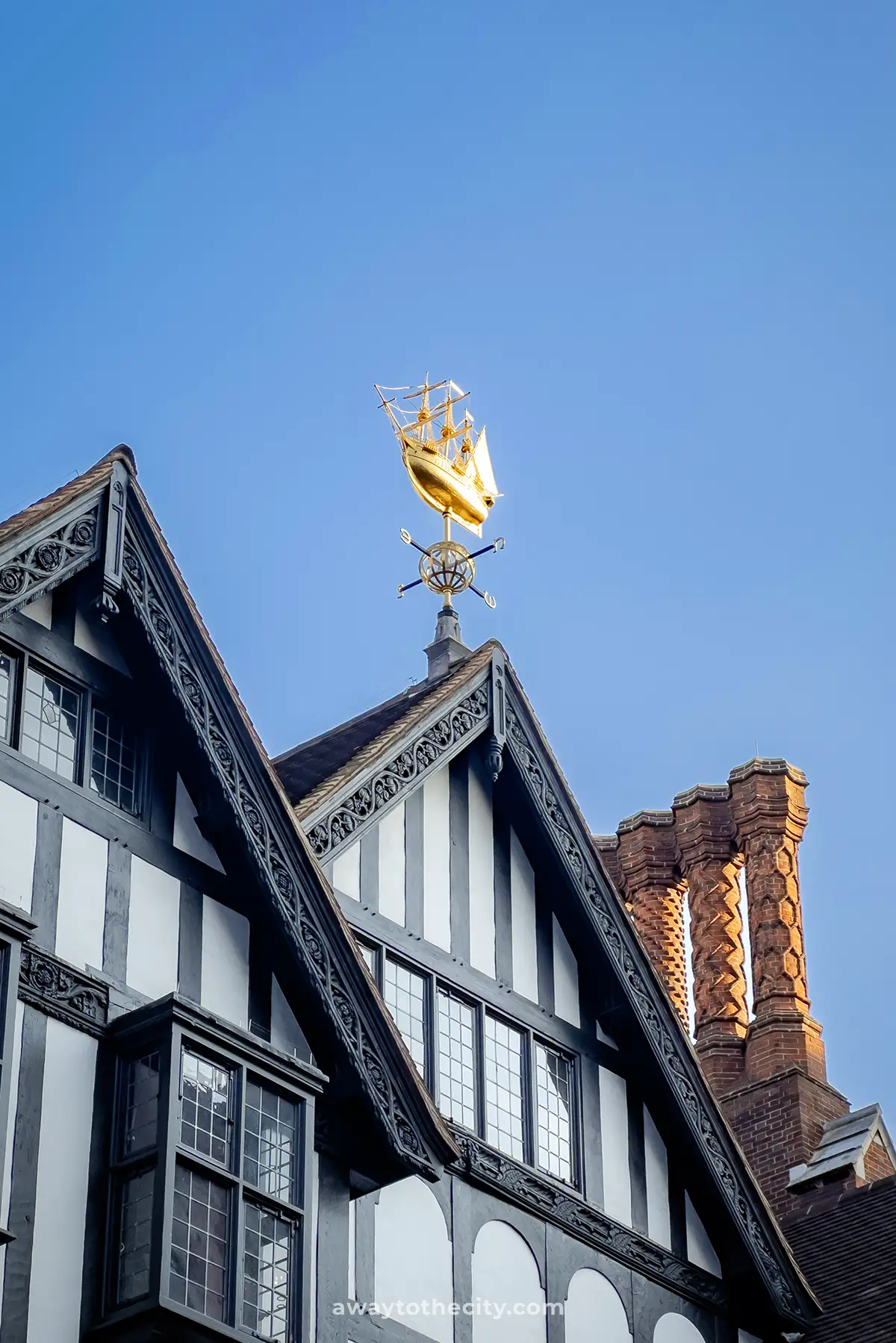 A golden weathervane shaped like the Mayflower ship sits atop the Liberty London building.