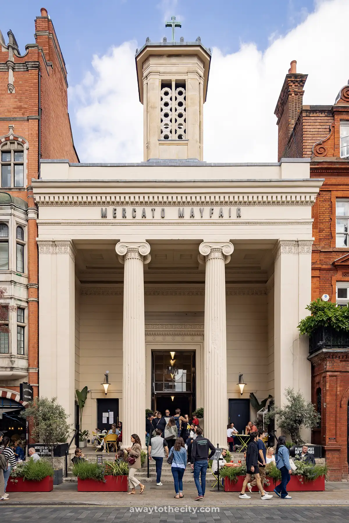 The grand entrance of Mercato Mayfair, a repurposed church, is busy with people.